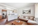 Bright, open living space with wood floors, neutral decor, and stainless steel appliances at 4233 Shoshone St, Denver, CO 80211