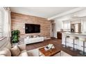 Stylish living room showcasing wood accent wall, modern decor, and open layout to the kitchen at 4233 Shoshone St, Denver, CO 80211
