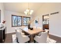 Dining room featuring a chandelier, wood floors, and large windows with blinds at 8159 Lodgepole Trl, Lone Tree, CO 80124