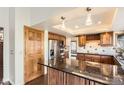 Stylish kitchen with stainless steel appliances, granite countertops, an island, and wood cabinetry at 8159 Lodgepole Trl, Lone Tree, CO 80124