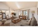 Bright living room with large windows, hardwood floors, and comfortable seating arrangement at 8159 Lodgepole Trl, Lone Tree, CO 80124