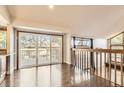 View of indoor living space with hardwood floors, a large sliding glass door to a patio, and wood railing at 8159 Lodgepole Trl, Lone Tree, CO 80124