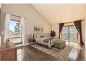 Spacious main bedroom featuring a large window, vaulted ceiling, and a private balcony with sliding glass doors at 8159 Lodgepole Trl, Lone Tree, CO 80124
