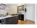 Stylish kitchen with sleek cabinetry, modern appliances, an island with a cooktop, and hardwood flooring at 789 N Clarkson St # 906, Denver, CO 80218
