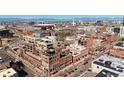 Stunning aerial view of a modern brick building complex in a vibrant city with distant mountain views at 1499 Blake St # 3M, Denver, CO 80202