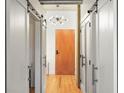 Bright hallway with white sliding doors and a modern sputnik light fixture illuminating the space at 1499 Blake St # 3M, Denver, CO 80202