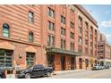 Street perspective of the Ice House, highlighting its brick facade, historic details, and prominent signage at 1801 Wynkoop St # 208, Denver, CO 80202