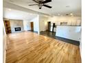 Bright open-concept living room with hardwood floors, fireplace, and seamless flow to the kitchen at 6040 W Elmhurst Dr, Littleton, CO 80128