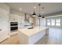 Modern kitchen featuring stainless steel appliances, white cabinets and a waterfall island at 8555 Hotchkiss St, Littleton, CO 80125