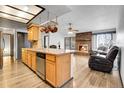 The open-concept kitchen features wood cabinets, stainless steel appliances, and flows seamlessly into the living area at 10142 Josephine St, Thornton, CO 80229