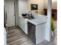 Functional kitchen area with stainless steel dishwasher, stylish countertops, and modern flooring at 2008 S Hannibal St # A, Aurora, CO 80013