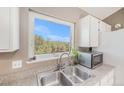 Close up of kitchen sink with view of foliage and granite countertops at 30819 Hilltop Dr, Evergreen, CO 80439