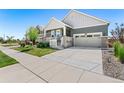 Residential street view showing a gray home with a two-car garage, front porch, and well-kept lawn at 872 S Flat Rock Way, Aurora, CO 80018