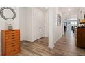 Bright hallway with wood floors, white walls, closet, and stylish decor, leading to dining area at 872 S Flat Rock Way, Aurora, CO 80018