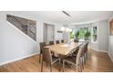 Bright dining room with a modern table set, wood floors, and large windows overlooking the front yard at 9673 Pinebrook St, Highlands Ranch, CO 80130