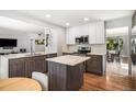 Well-lit kitchen with an island, hardwood floors, and granite countertops, offering a blend of style and functionality at 9673 Pinebrook St, Highlands Ranch, CO 80130