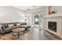 Inviting living room with fireplace, wood floors, and sliding glass doors at 9692 W Coco Cir # 103, Littleton, CO 80128