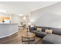 Living space with open access to the kitchen and dining area; wood floors at 9692 W Coco Cir # 103, Littleton, CO 80128