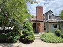 Charming home featuring a brick chimney, dormer windows, and lush landscaping for added curb appeal at 971 S Evanston Cir, Aurora, CO 80012