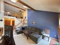 Bright living room with vaulted ceilings, wood beams, skylights, and an open staircase to the upper level at 971 S Evanston Cir, Aurora, CO 80012