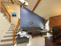 Bright living room with vaulted ceilings, wood beams, skylights, and an open staircase to the upper level at 971 S Evanston Cir, Aurora, CO 80012