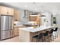 Modern kitchen featuring stainless steel appliances, a large island with seating, and stylish pendant lighting at 1571 Vrain St, Denver, CO 80204