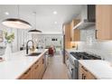 Contemporary kitchen boasts stainless steel appliances, a center island, and views into the living area at 1571 Vrain St, Denver, CO 80204