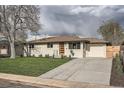 Beautiful single-story home with a well-manicured lawn and a wide driveway leading to an attached one-car garage at 2076 S Yates St, Denver, CO 80219