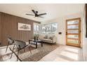 Bright living room with modern wood wall accents, stylish seating, and lots of natural light coming through the large window at 2076 S Yates St, Denver, CO 80219