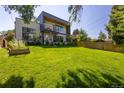 Expansive backyard with lush green lawn, patio area with seating, and mature trees, perfect for outdoor relaxation and entertainment at 3485 S Clermont St, Denver, CO 80222
