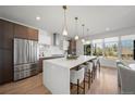 Bright kitchen with stainless steel appliances, large island with seating, pendant lights and large windows at 3485 S Clermont St, Denver, CO 80222
