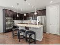 Modern kitchen boasts stainless steel appliances, granite countertops, an island with seating, and dark cabinets at 5439 Verbena St, Denver, CO 80238