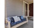 Inviting front porch with porch swing and comfortable pillows with the front door just steps away at 5439 Verbena St, Denver, CO 80238