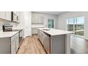 Well-lit kitchen with quartz countertop island and stainless steel appliances at 18998 E 94Th Pl, Commerce City, CO 80022