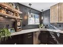 Kitchen area with modern countertops, subway tile backsplash, a stainless steel dishwasher, and open shelves at 8735 W Cornell Ave # 7, Lakewood, CO 80227