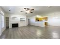 Spacious living room with fireplace, ceiling fan, hardwood floors, and open kitchen with granite countertops at 14333 E 1St Dr # 108, Aurora, CO 80011
