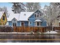 Charming blue house with snow and wooden fence enhancing the curb appeal at 1605 17Th St, Boulder, CO 80302
