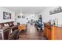 Open concept living area featuring hardwood floors, comfortable seating, and dining area beyond at 1155 N Ash St # 1408, Denver, CO 80220