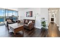 Cozy living room with a leather sofa and a large window showcasing city views at 1155 N Ash St # 1408, Denver, CO 80220