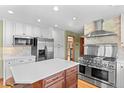 Modern kitchen with stainless steel appliances, a large island, white cabinets, and a brick backsplash at 8000 S Williams Way, Centennial, CO 80122