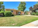 Charming single-story brick home features a well-manicured lawn and long driveway at 3354 W Arlington Ave, Littleton, CO 80123
