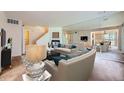 Open-concept living room featuring neutral tones, a fireplace, and mirrored wall creating a spacious ambiance at 2557 S Dover St # 25, Lakewood, CO 80227