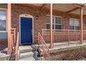 Charming brick townhome front entrance featuring blue door and cozy porch area at 7883 W 55Th Ave, Arvada, CO 80002