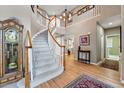 Grand foyer with a winding staircase, hardwood floors, and a view into adjacent living spaces at 10305 Charissglen Cir, Highlands Ranch, CO 80126