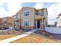 Inviting townhome featuring stone accents, covered front porch and concrete walkway at 5154 Bittercress Rd, Brighton, CO 80640