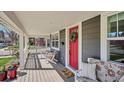 Inviting front porch with comfortable seating, a vibrant red door, and charming decor at 2801 Cherry St, Denver, CO 80207