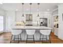 Bright kitchen with stainless appliances, white cabinets, and a large island with seating at 2801 Cherry St, Denver, CO 80207