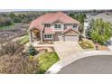 Stunning aerial view of a two-story home with a beautiful red tile roof and landscaped front yard at 23965 E Kettle Pl, Aurora, CO 80016