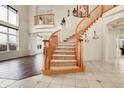 Elegant foyer showcasing a curved staircase, tile, and wood flooring at 23965 E Kettle Pl, Aurora, CO 80016