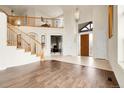 Bright, open-concept living room featuring a grand staircase, light tile flooring, and neutral walls at 23965 E Kettle Pl, Aurora, CO 80016